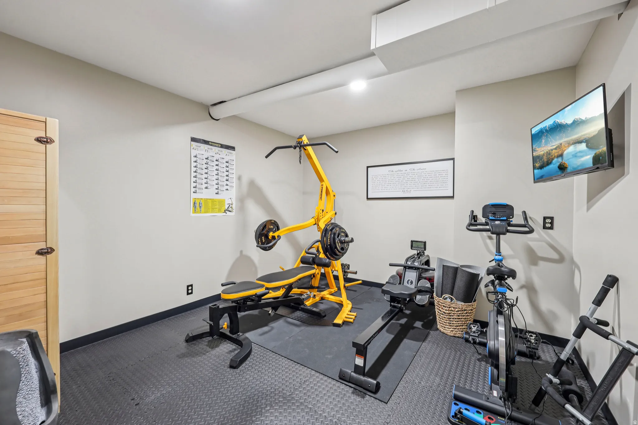 Workout room featuring dark colored carpet and baseboards