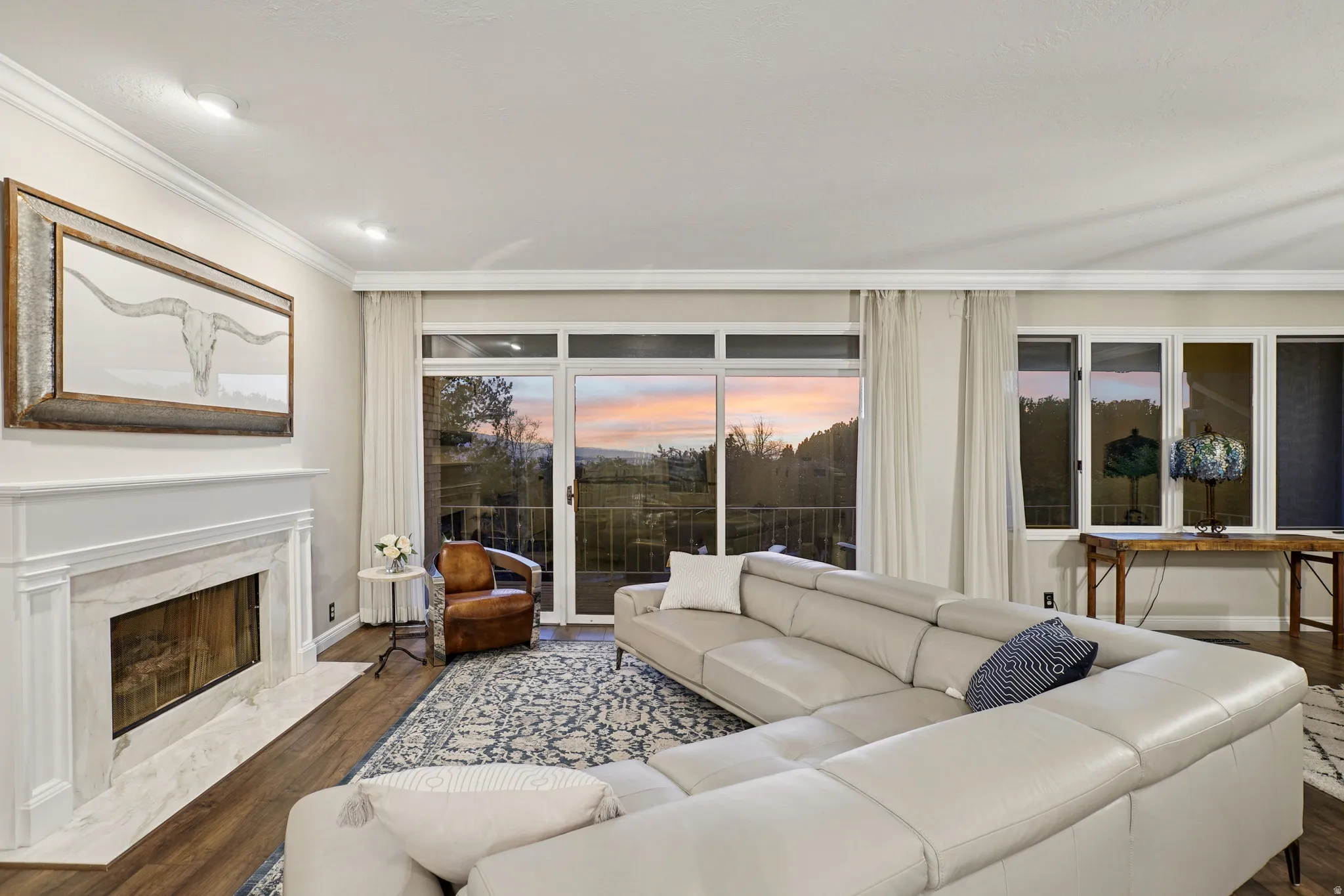 Living room featuring dark wood finished floors, crown molding, and a premium fireplace