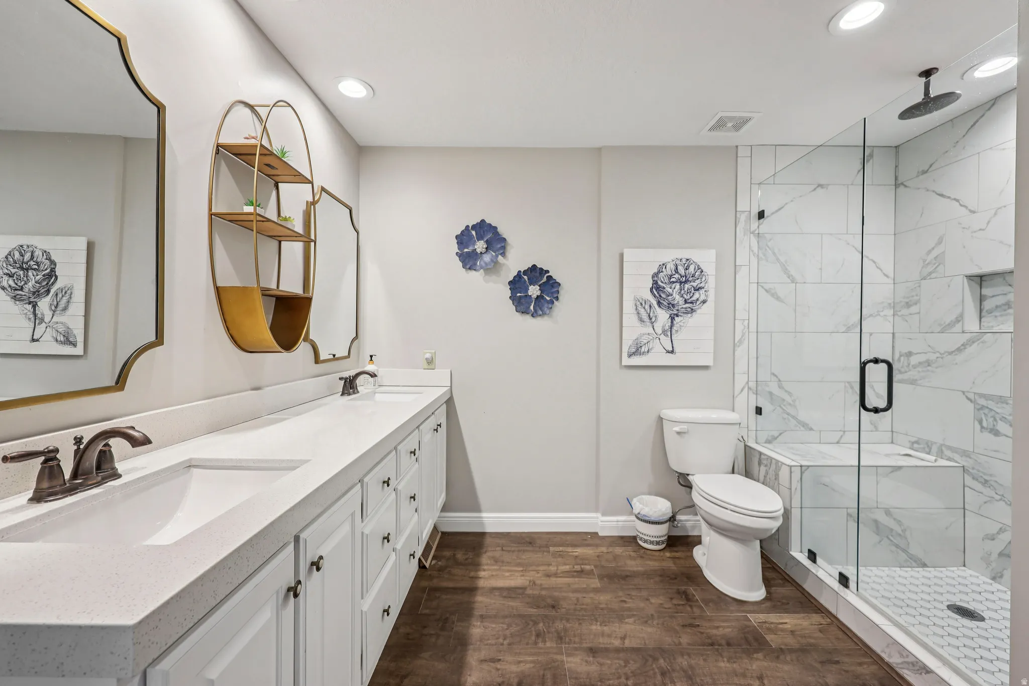 Bathroom with double vanity, dark wood-type flooring, a marble finish shower, and recessed lighting
