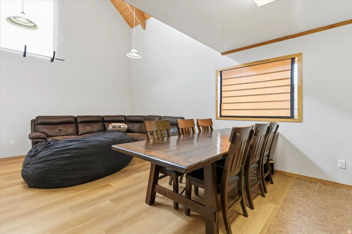 Dining room with vaulted ceiling with beams and light wood-type flooring