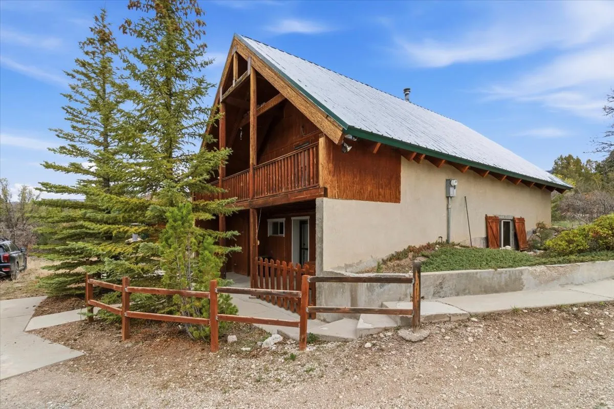 View of side of property featuring a metal roof and a balcony