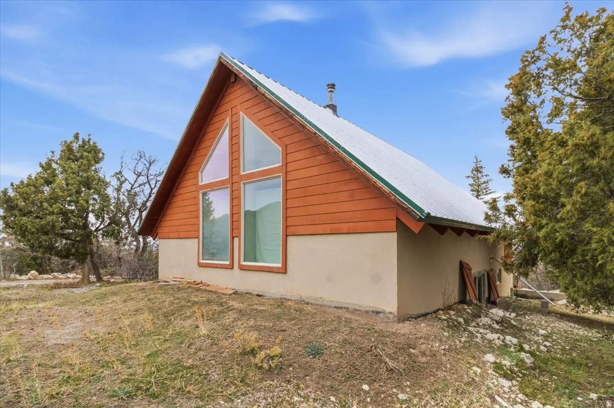View of home's exterior with a metal roof, a yard, and stucco siding