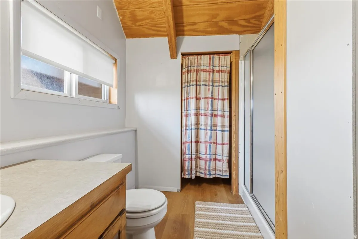 Bathroom with a stall shower, light wood-type flooring, and vanity