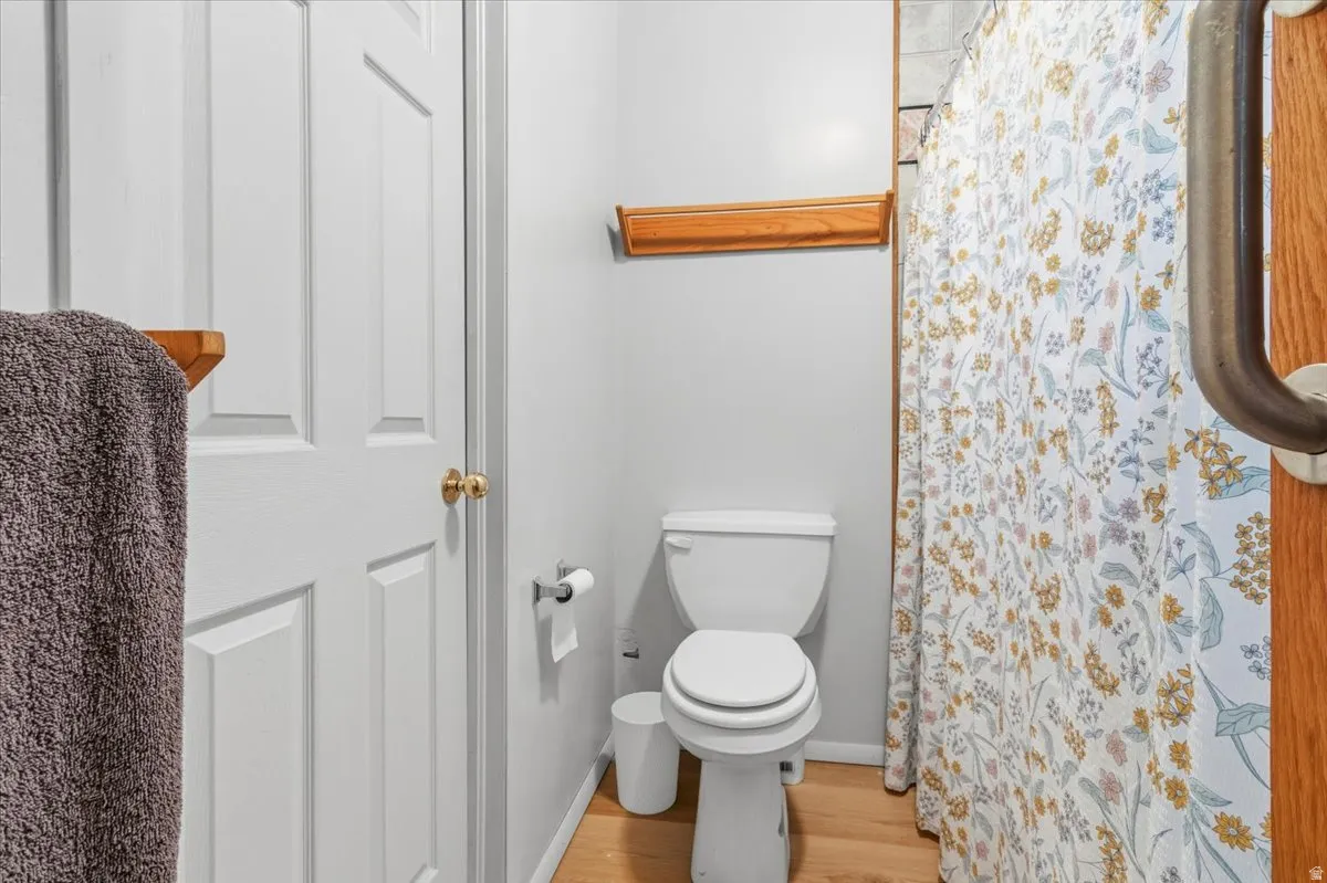 Full bathroom featuring a shower with curtain and light wood-type flooring