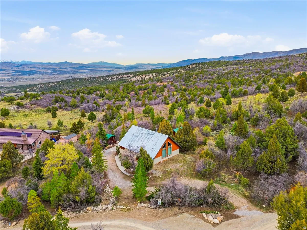 Aerial view of property and surrounding area with a mountainous background