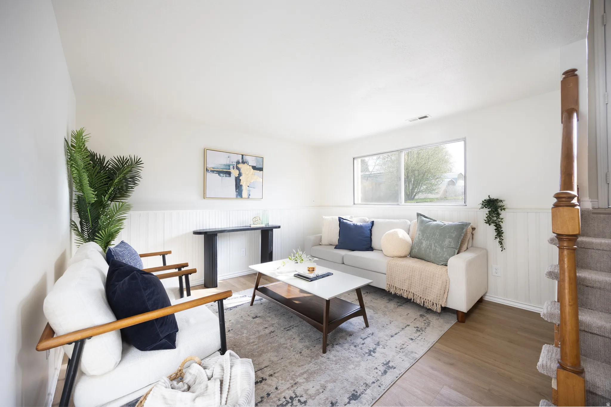 Living area with wood finished floors and wainscoting