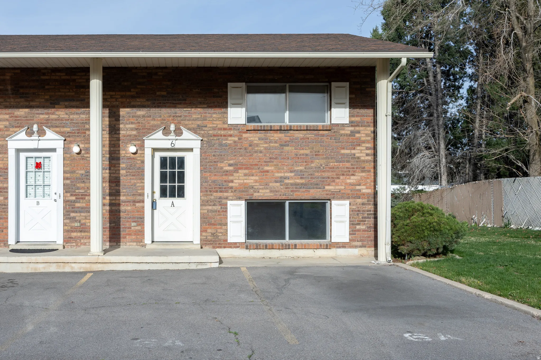 View of front facade with brick siding and uncovered parking