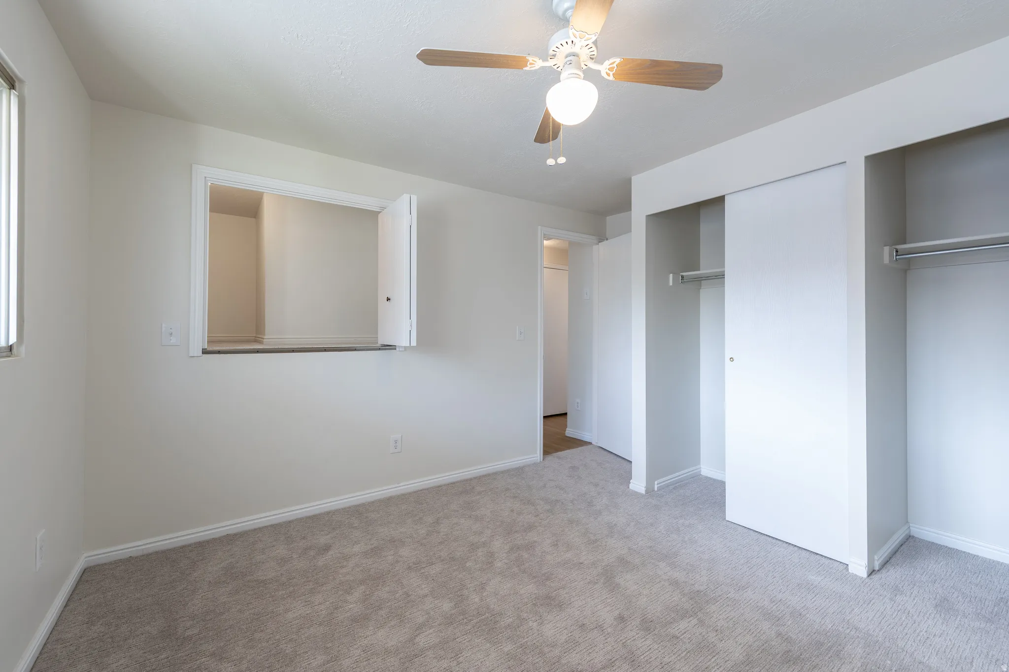 Unfurnished bedroom with carpet floors, ceiling fan, and multiple closets