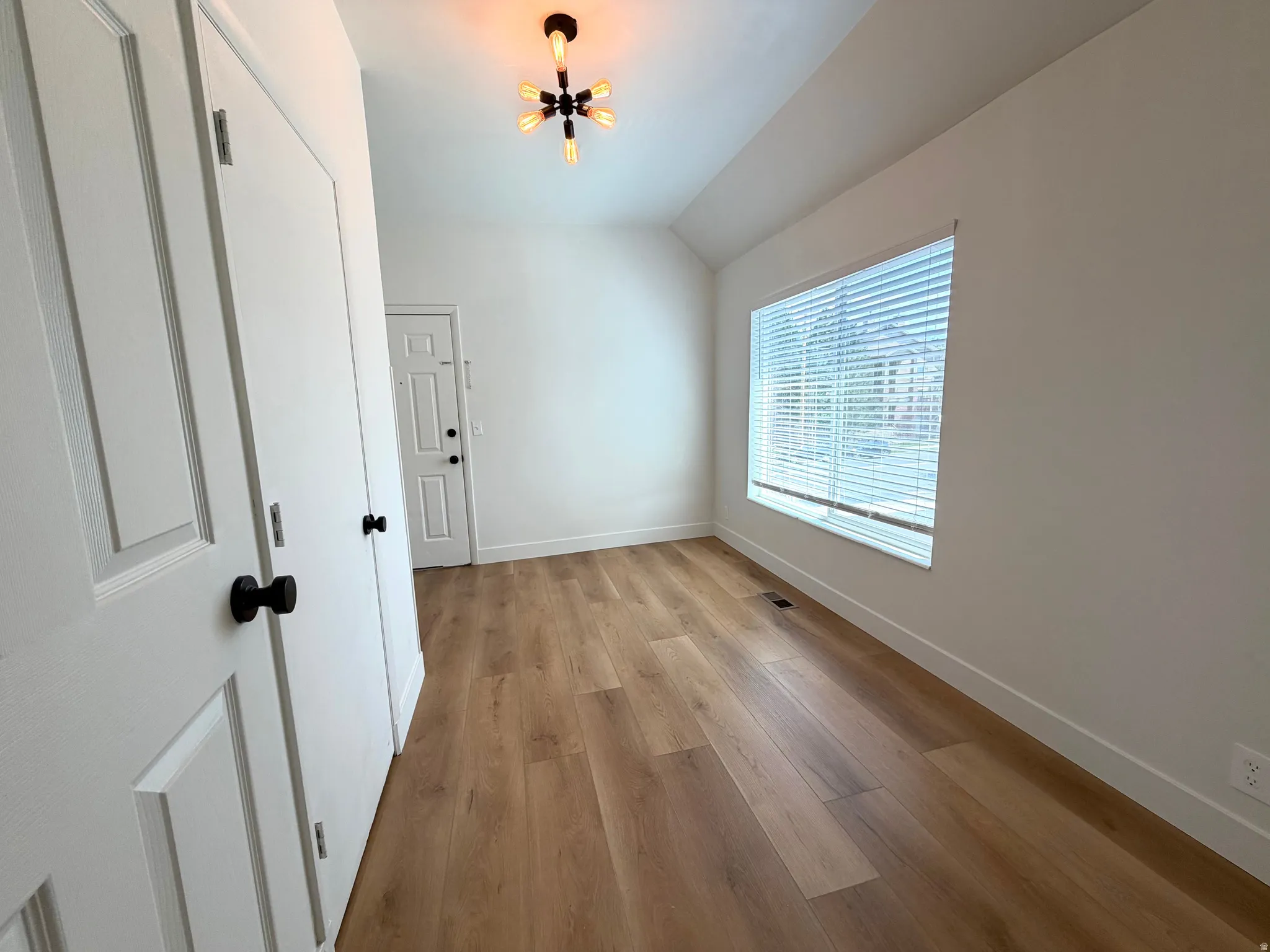 Wood-finish flooring, white walls, and a contemporary ceiling light fixture