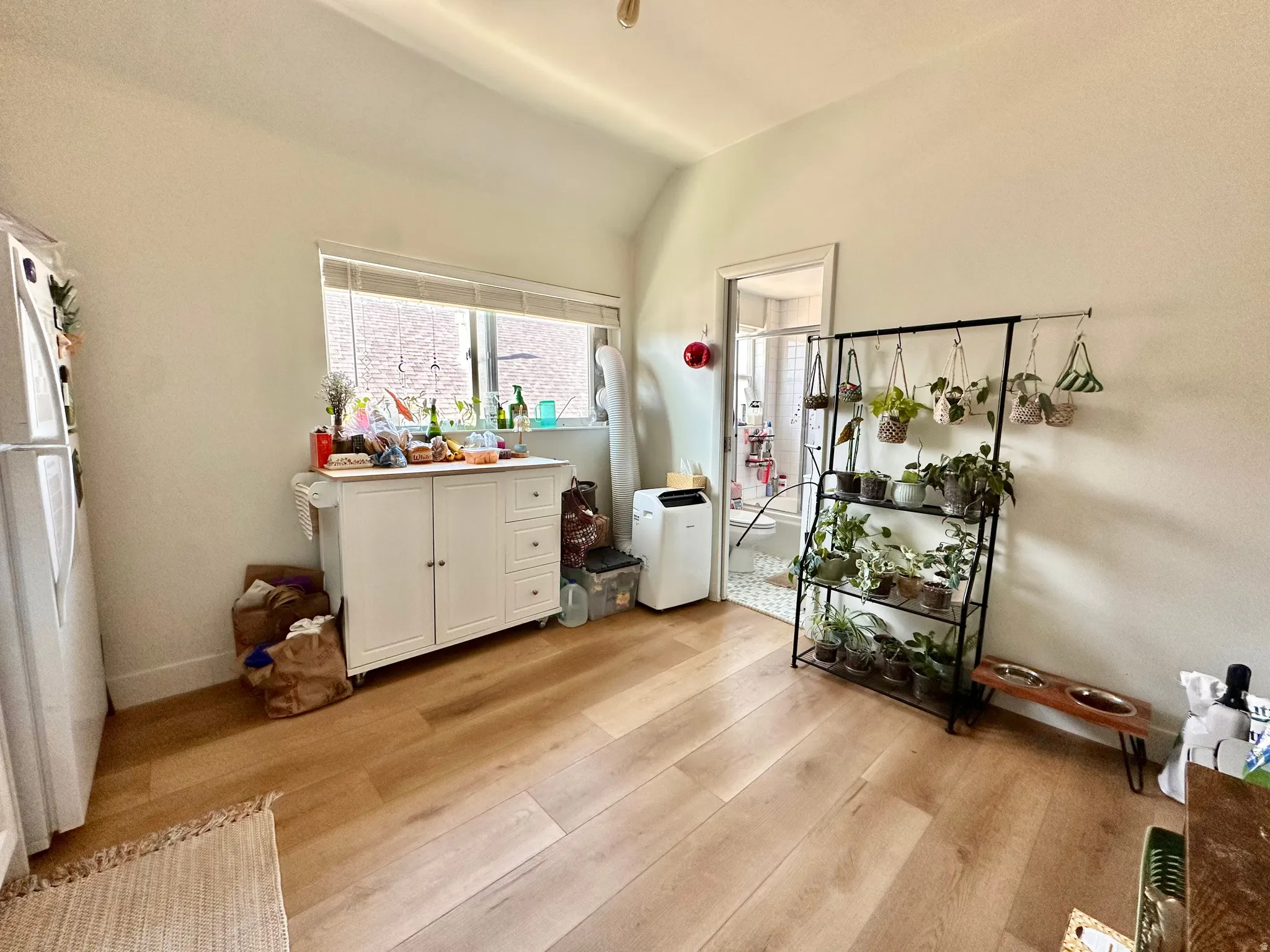 Dining area with light wood-style flooring and lofted ceiling