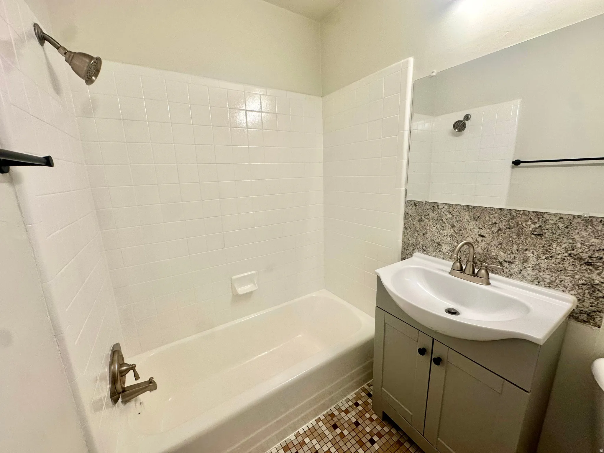 Bathroom featuring a white bathtub and shower with white subway tile surround