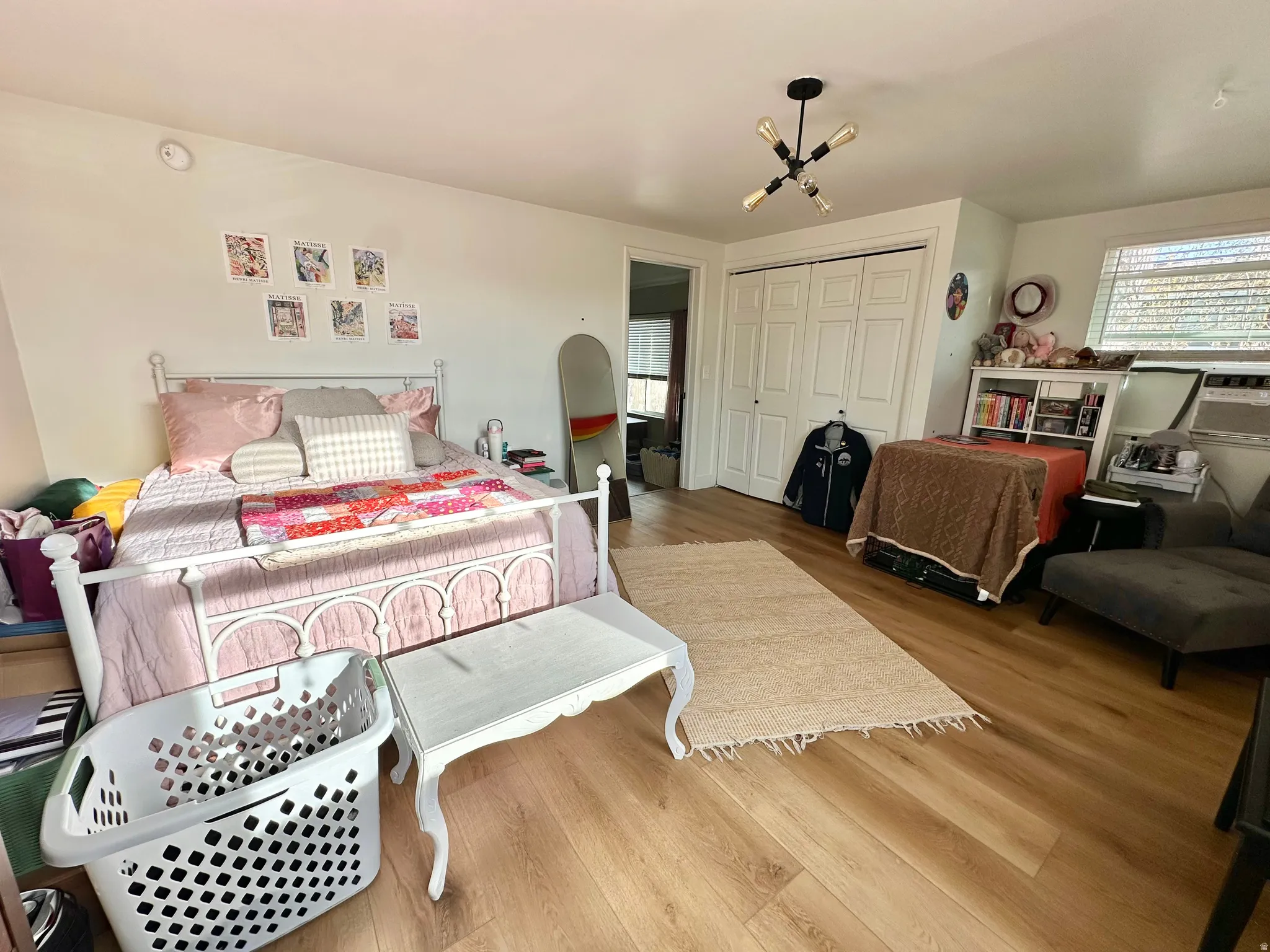 Bedroom featuring wood finished floors, multiple windows, and a closet