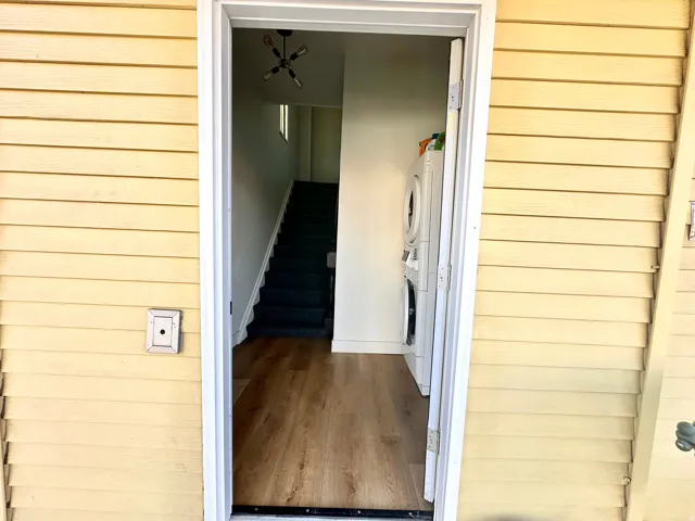 Doorway to property featuring stacked washer / dryer