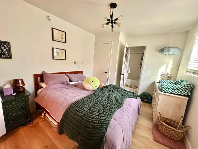 Bedroom featuring wood finished floors and ensuite bathroom