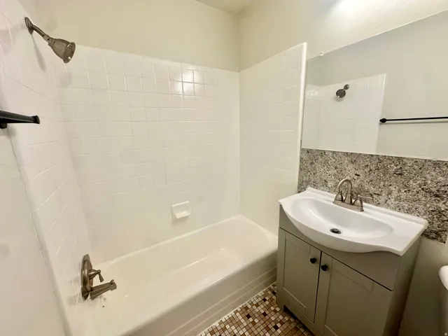 Bathroom featuring a white bathtub and shower with white subway tile surround