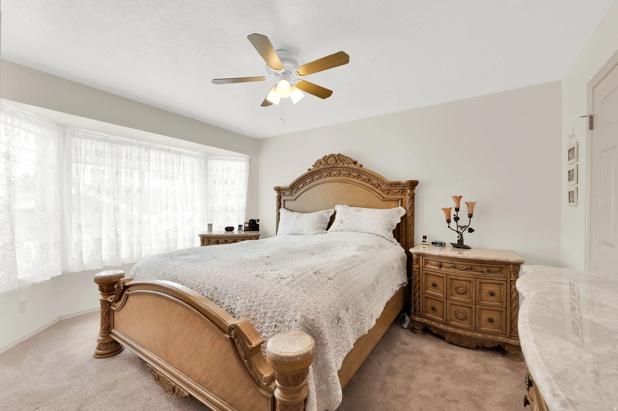 Bedroom featuring light colored carpet and ceiling fan