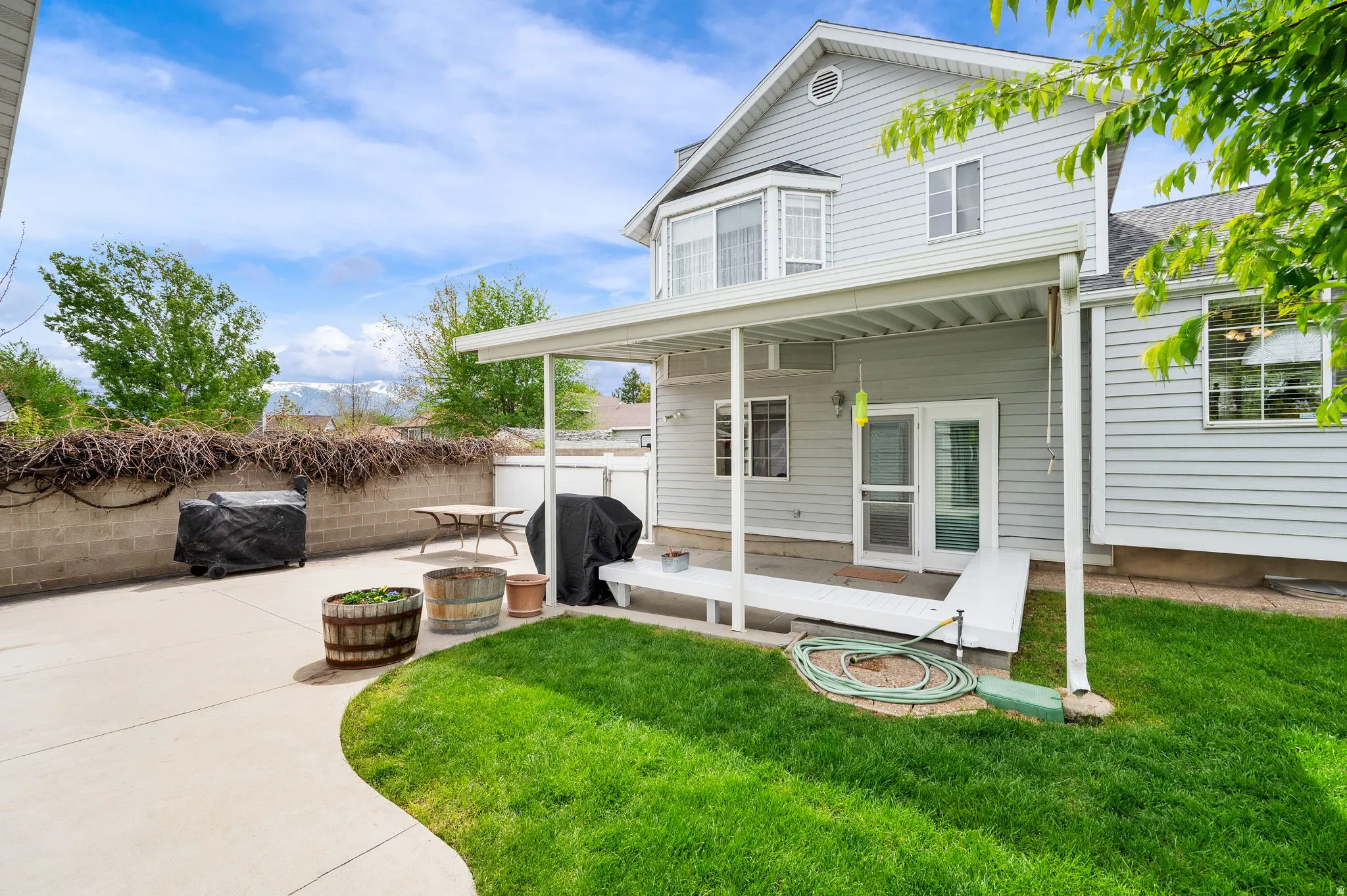 Back of property featuring a fenced backyard and a patio