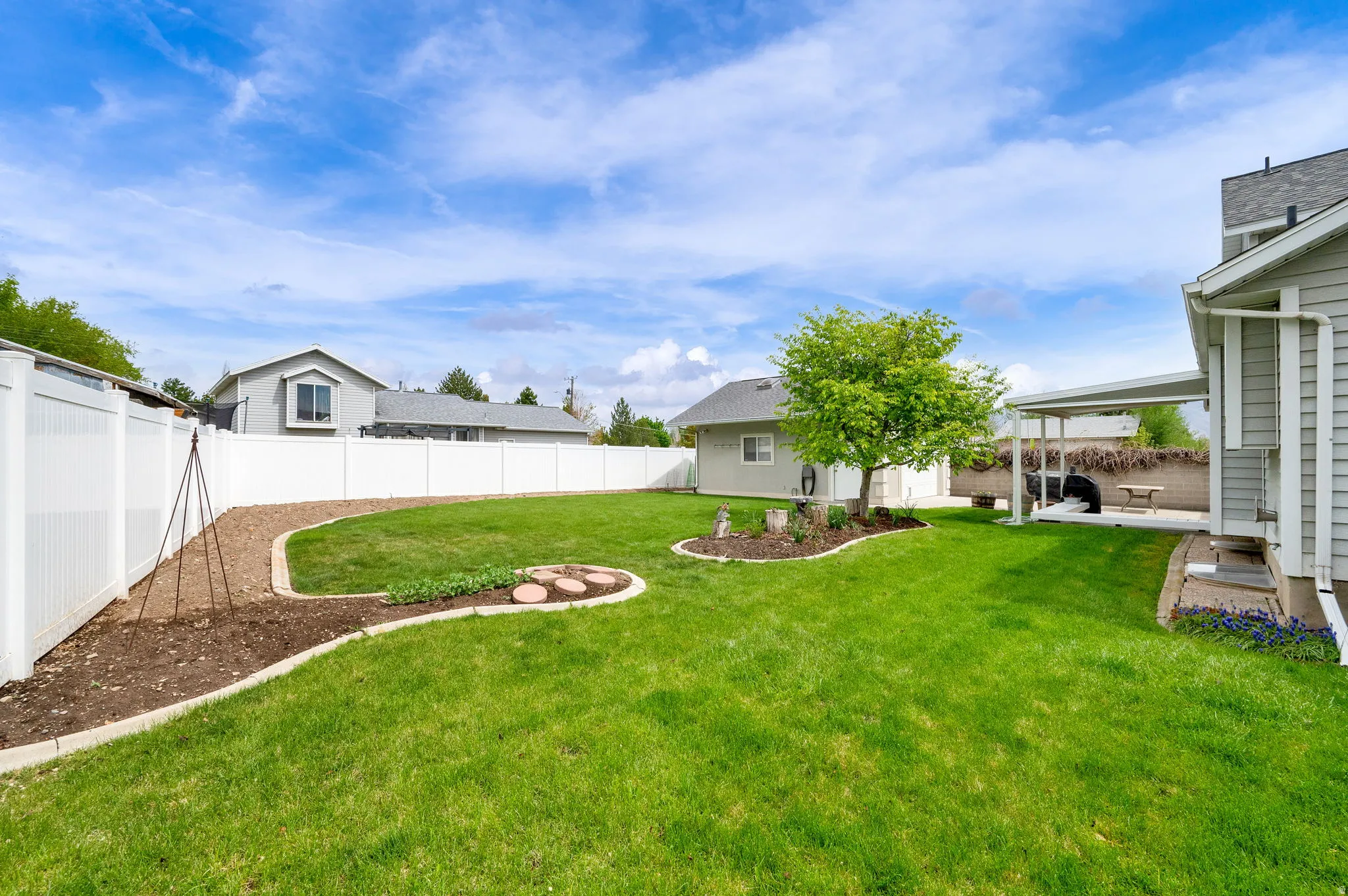 Fenced backyard with a patio area and an outbuilding