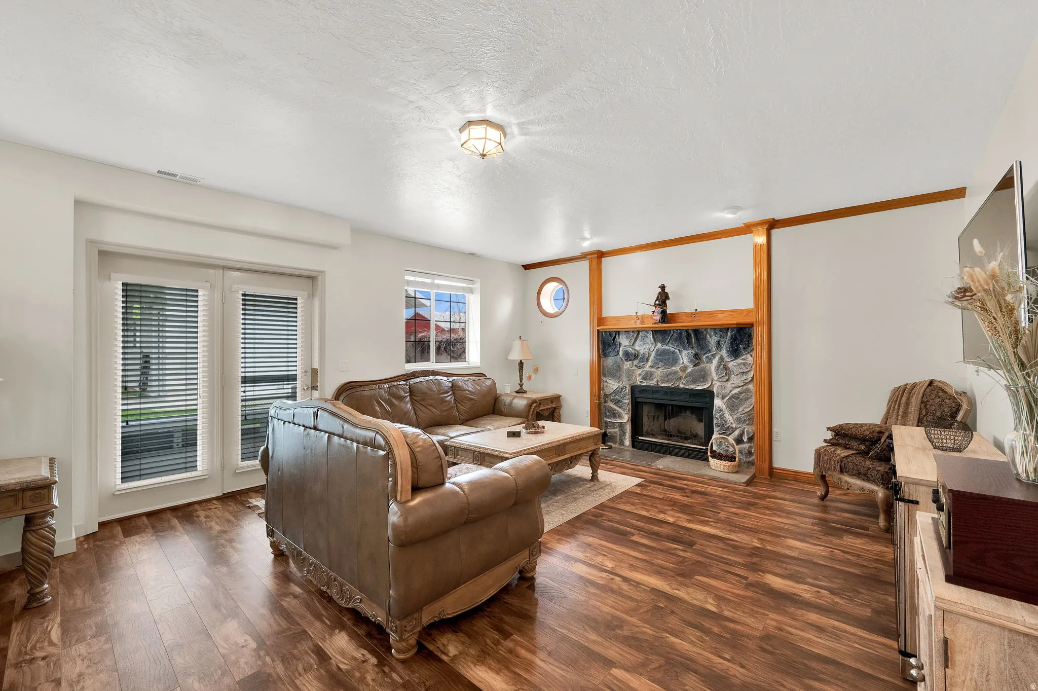 Living area with dark wood finished floors, a fireplace, and a textured ceiling