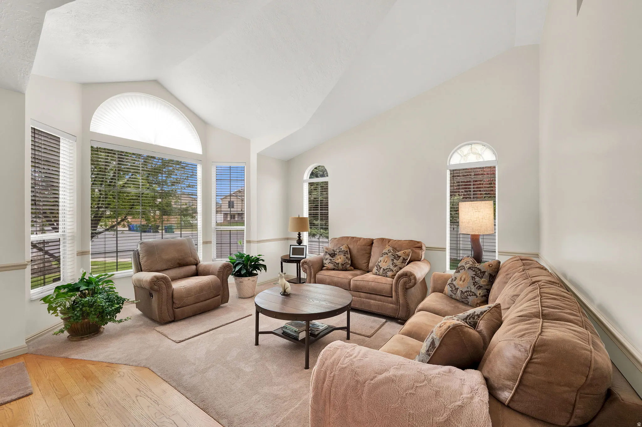 Living area with vaulted ceiling and hardwood / wood-style floors