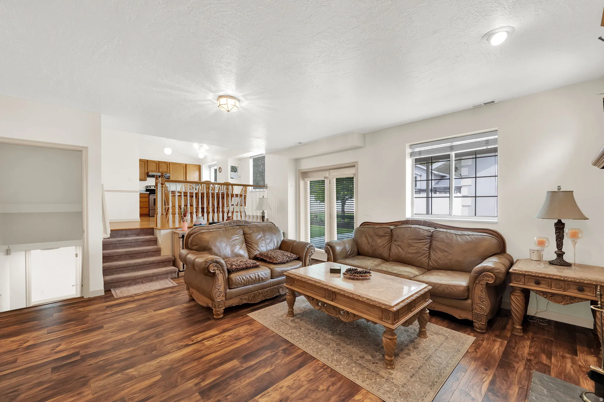 Living room featuring dark wood-type flooring and a textured ceiling