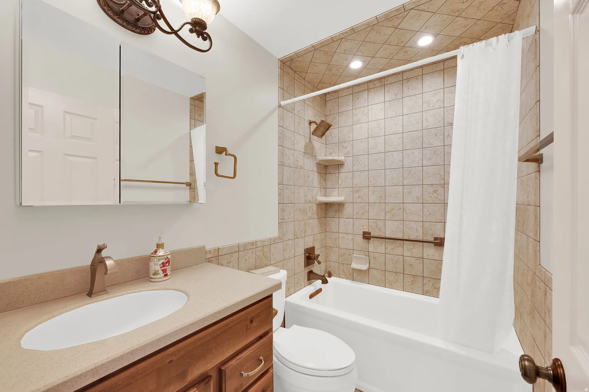 Full bathroom featuring vanity, shower / bathtub combination with curtain, and recessed lighting