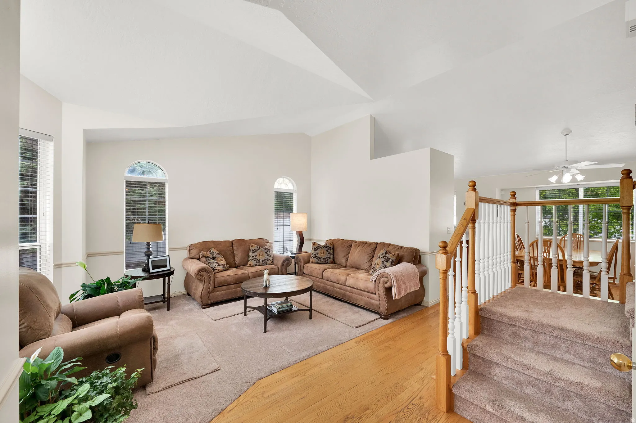 Living area with wood-type flooring, lofted ceiling, ceiling fan, and plenty of natural light