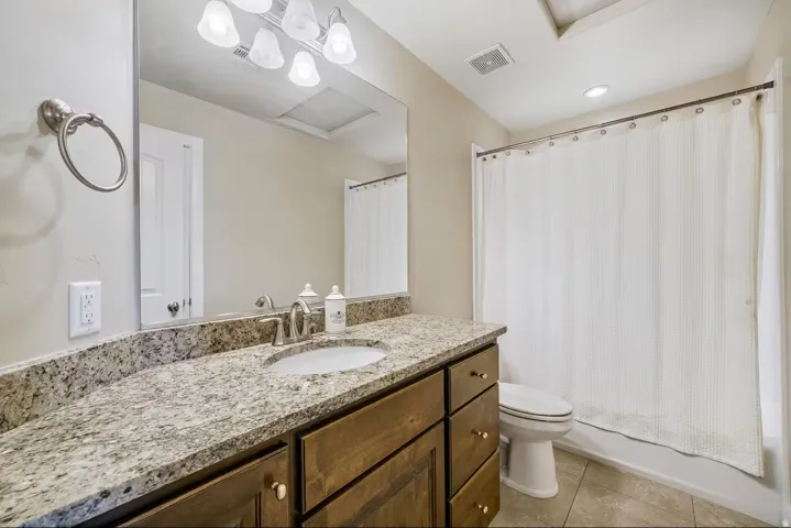 Full bath with vanity, light tile patterned flooring, and shower / bath combo