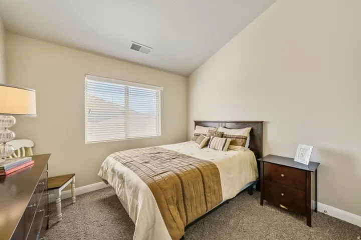 Bedroom featuring lofted ceiling and dark colored carpet