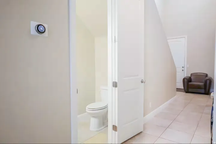 Bathroom with light tile patterned floors and lofted ceiling