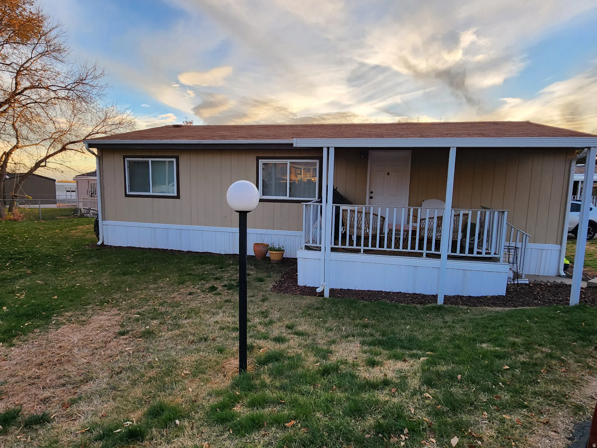 Manufactured / mobile home featuring roof with shingles and covered porch