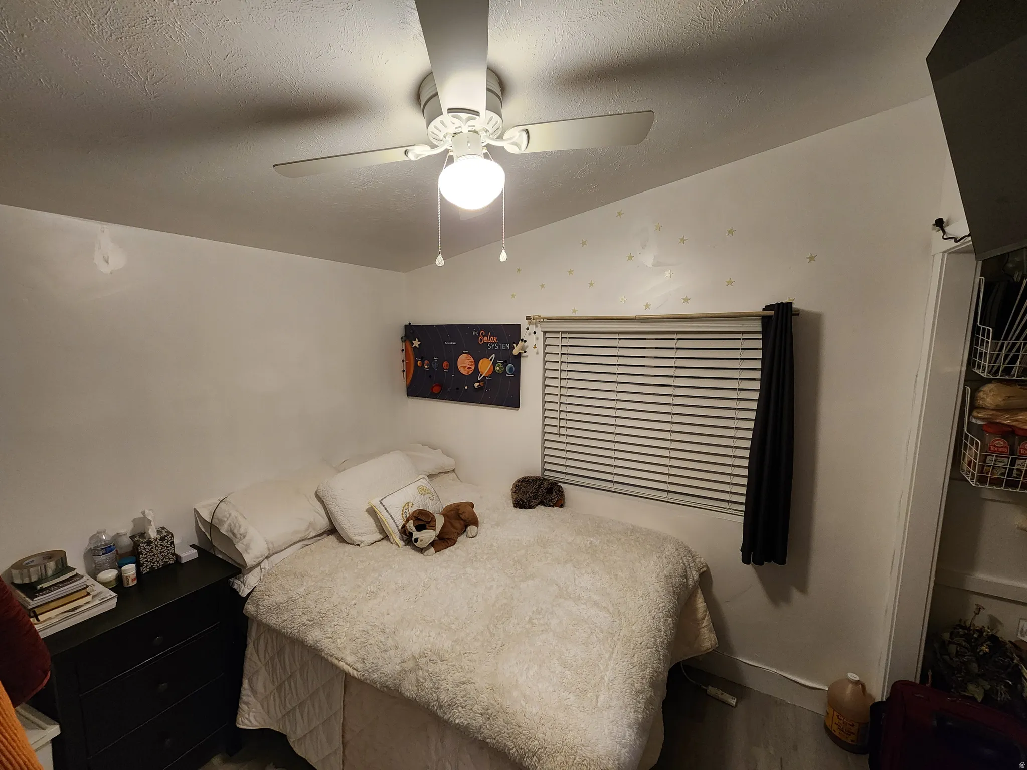 Bedroom featuring a ceiling fan and a textured ceiling
