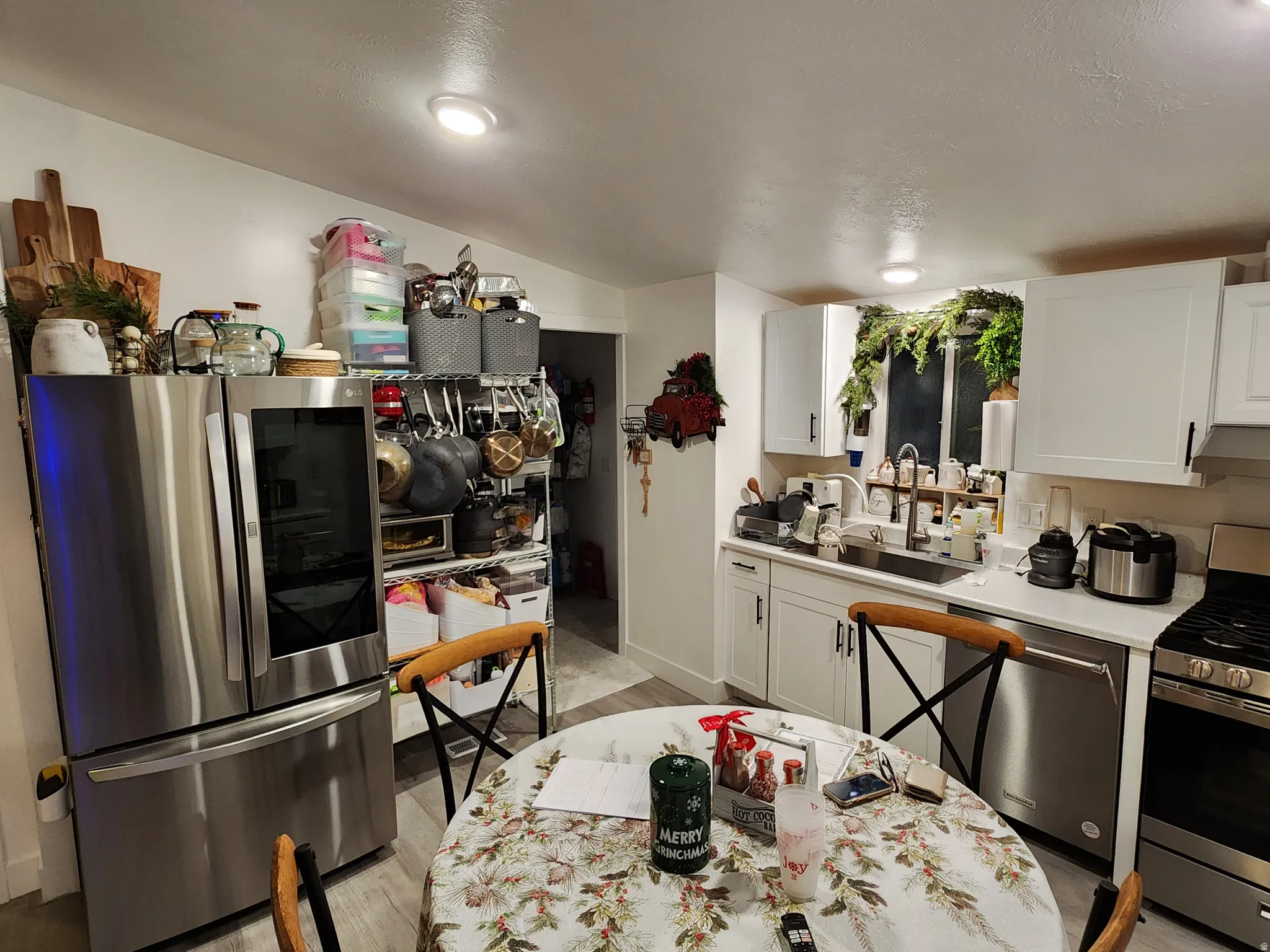 Kitchen with white cabinets, stainless steel appliances, and light wood-type flooring