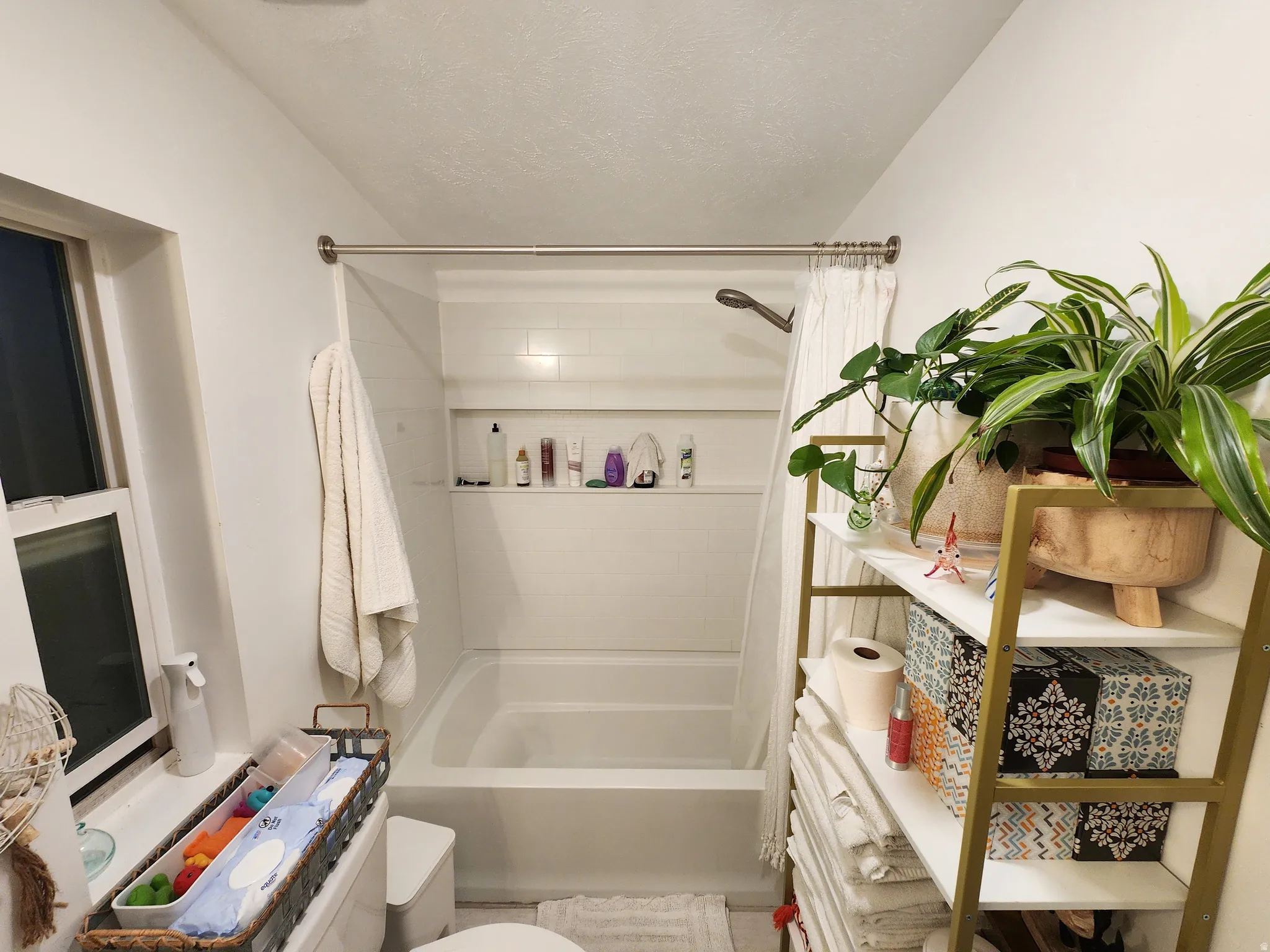 Full bathroom with shower / bath combo, vanity, and a textured ceiling
