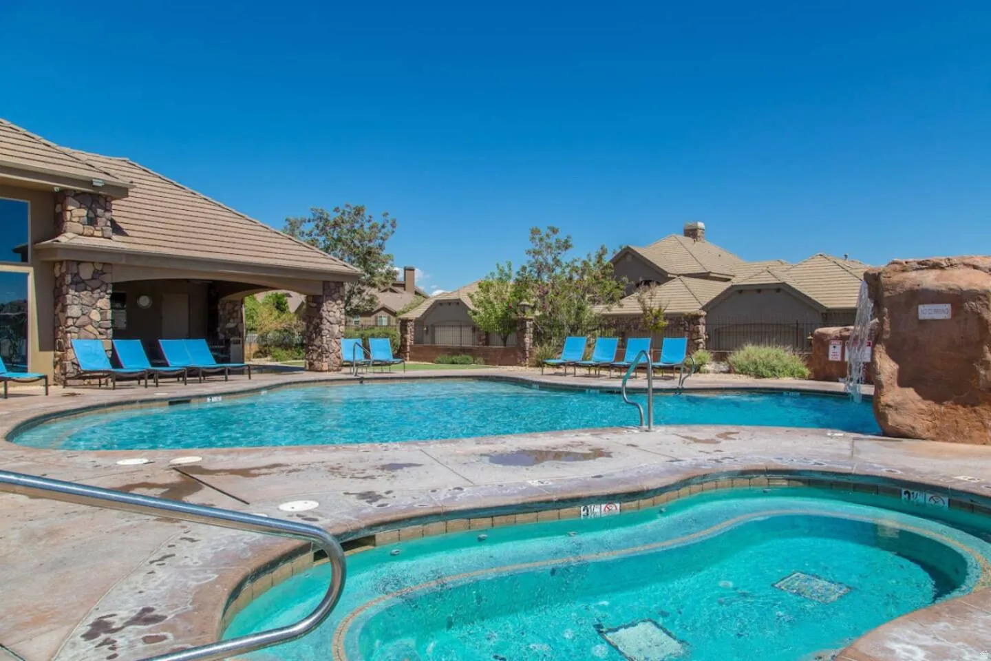 Community pool with a patio and a hot tub