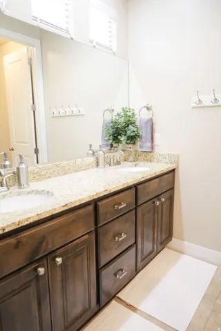 Bathroom featuring double vanity and baseboards