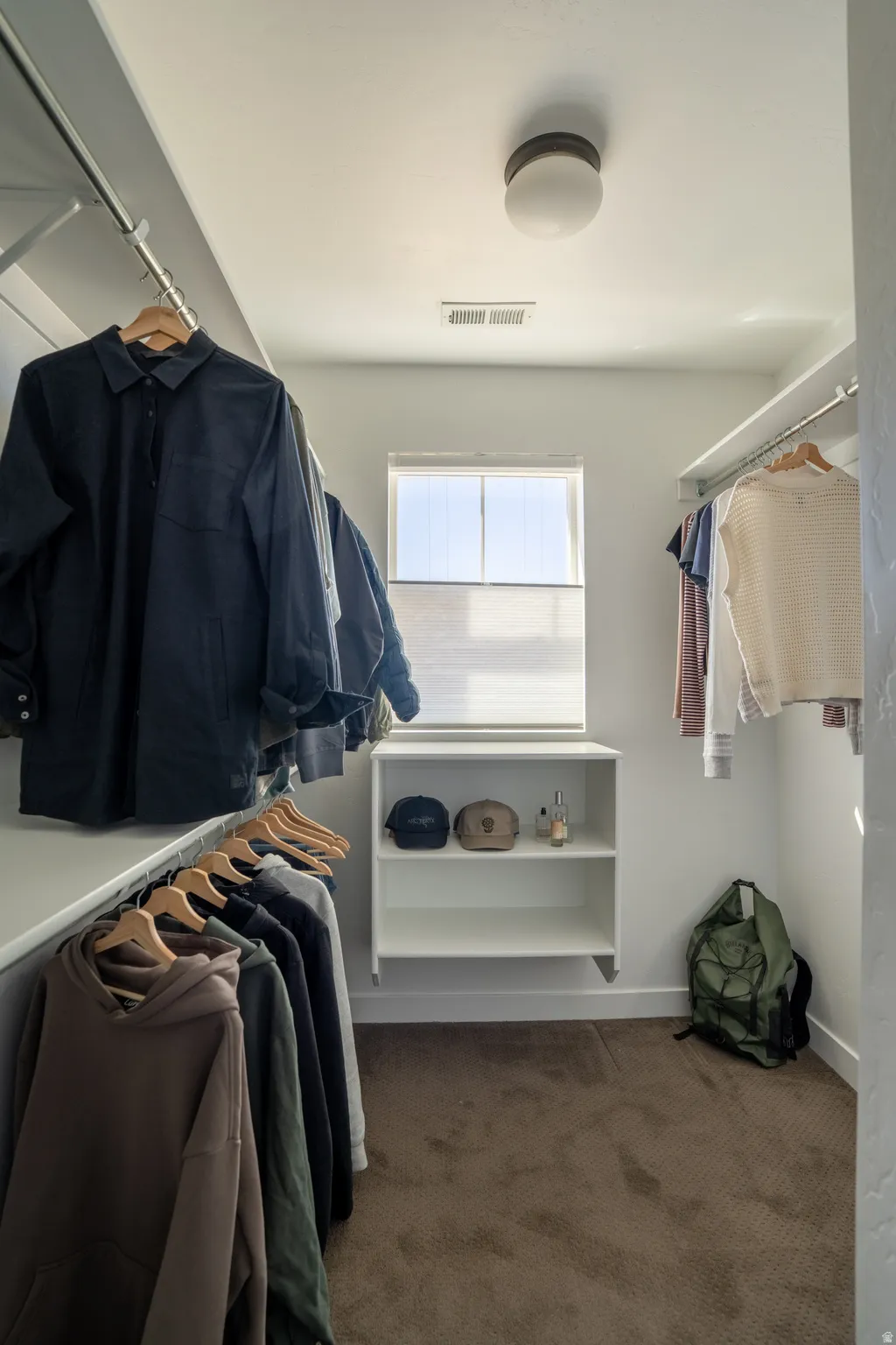 Walk in closet featuring dark carpet