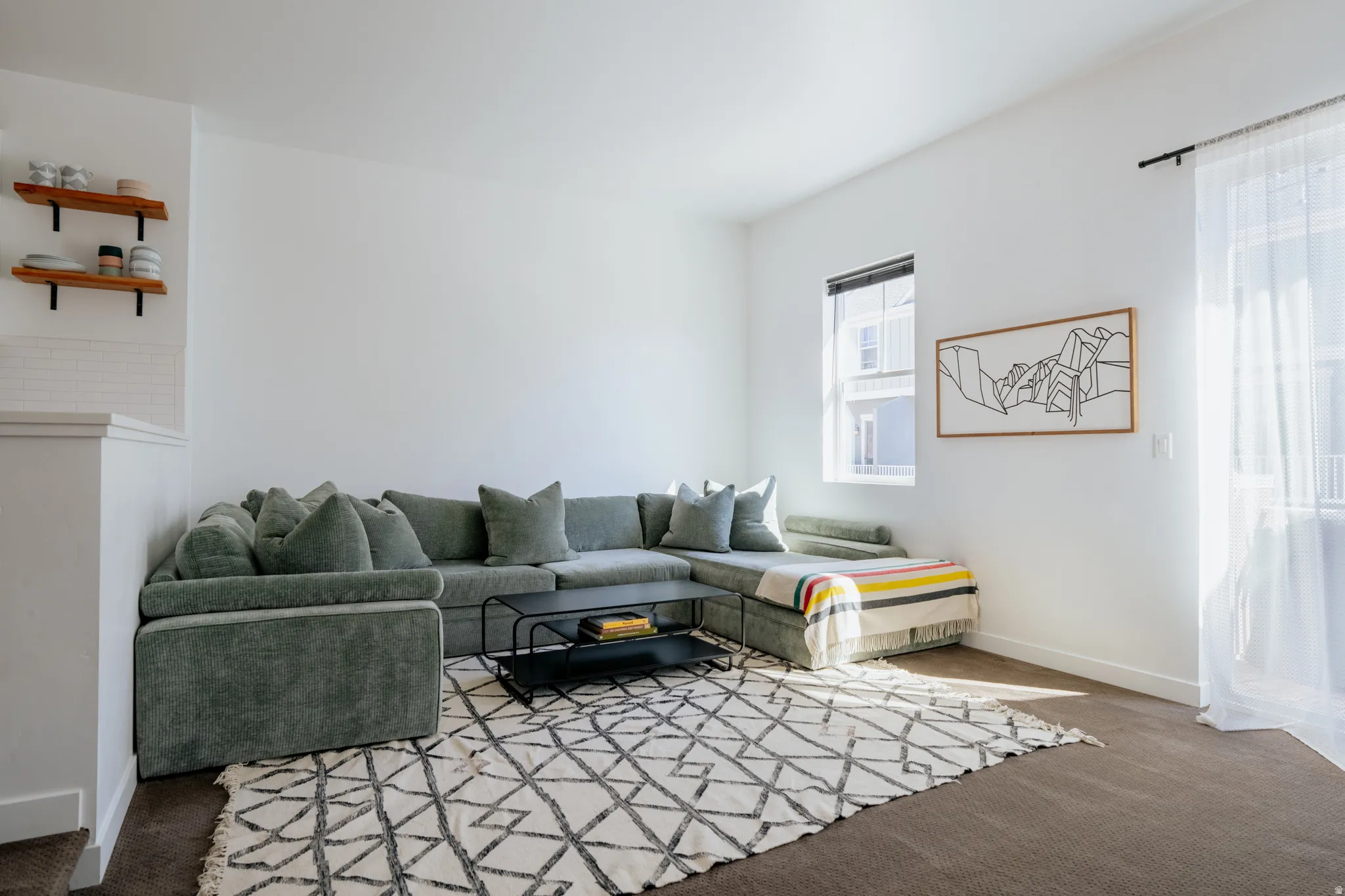 Carpeted living area featuring baseboards