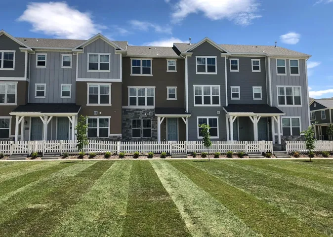 Rear view of house with board and batten siding, a porch, and stone siding