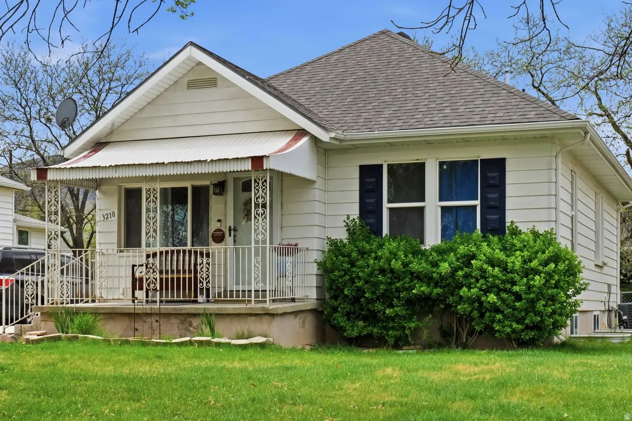 Bungalow-style home featuring a porch, a front lawn, and roof with shingles