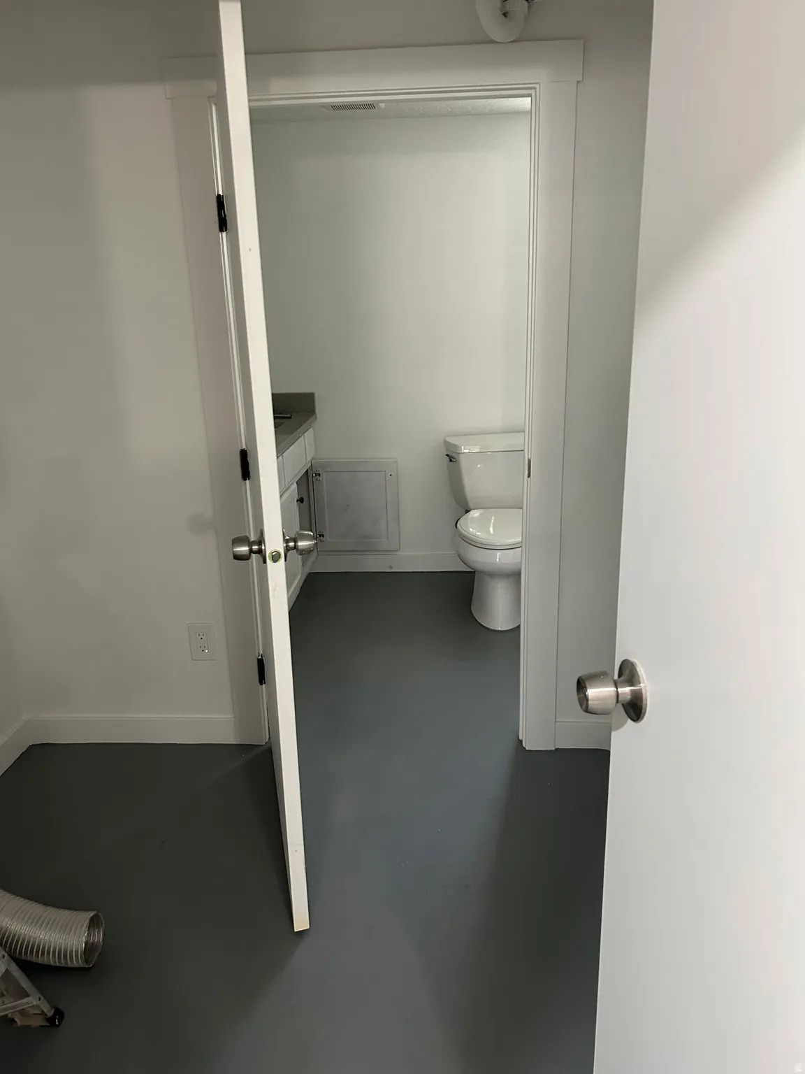 Half bath featuring vanity and finished concrete flooring