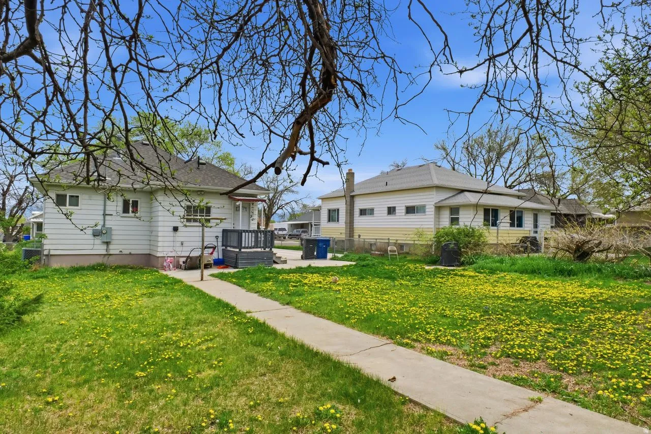 View of property exterior featuring a lawn and a deck