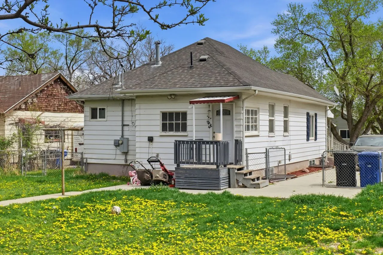 Rear view of property with roof with shingles and a gate