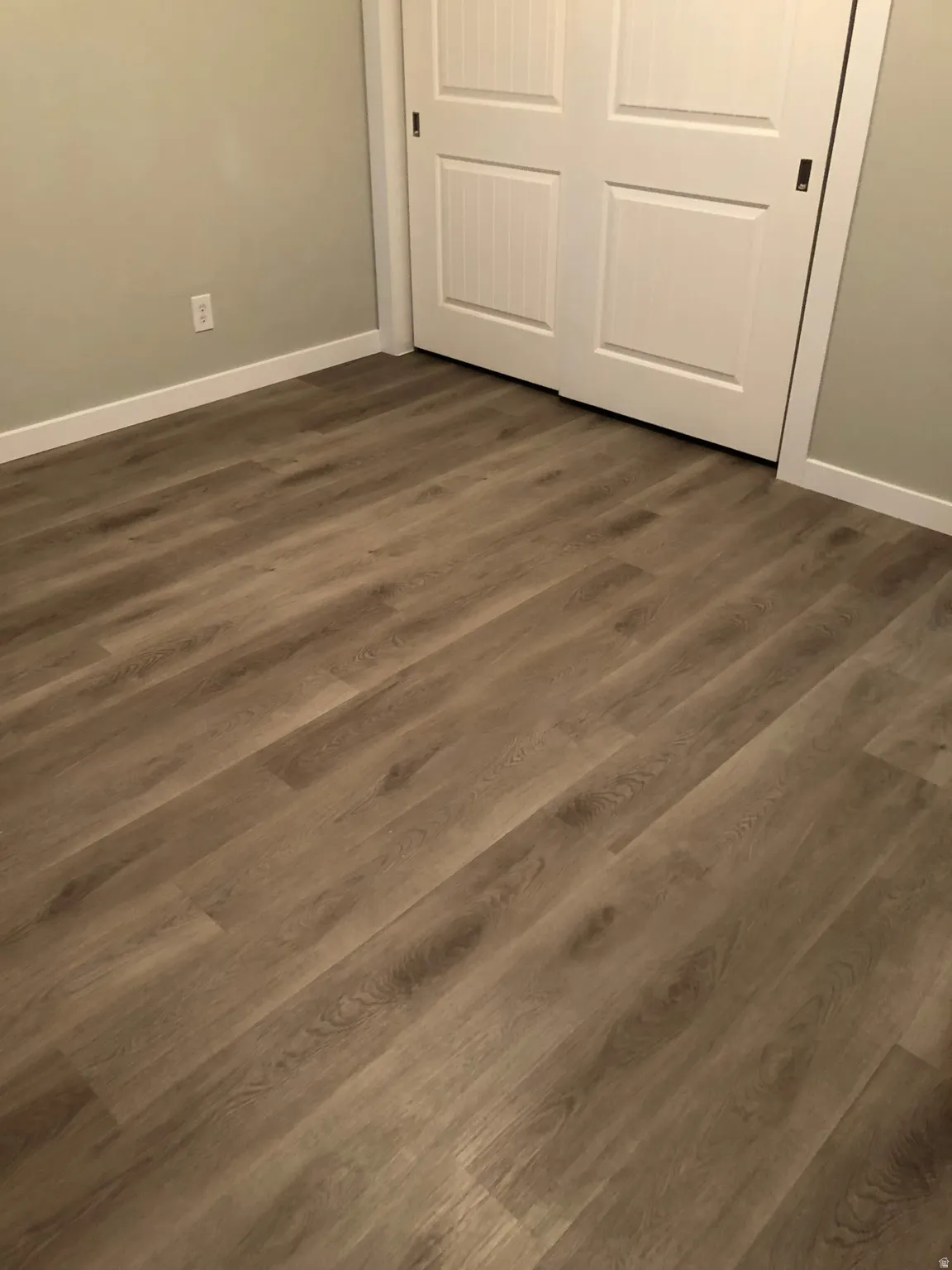 Unfurnished bedroom featuring a closet and dark wood-style floors