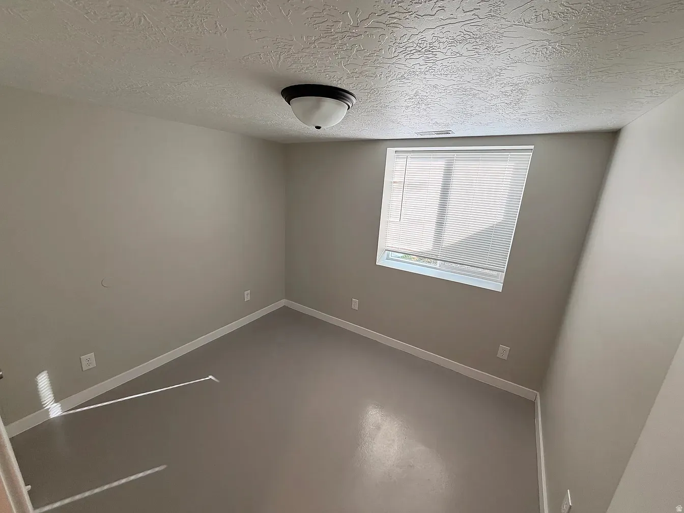 Spare room featuring concrete floors and a textured ceiling