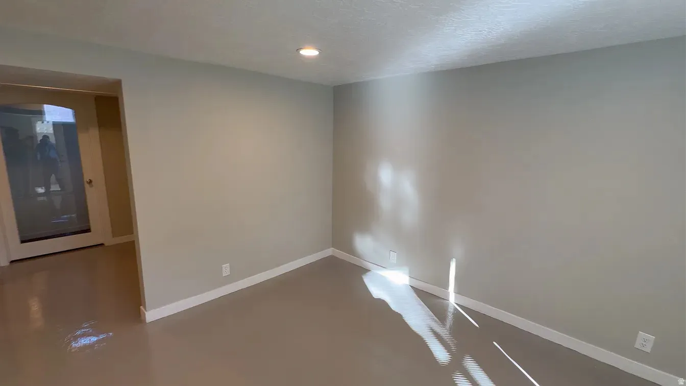 Unfurnished room with finished concrete floors, recessed lighting, and a textured ceiling