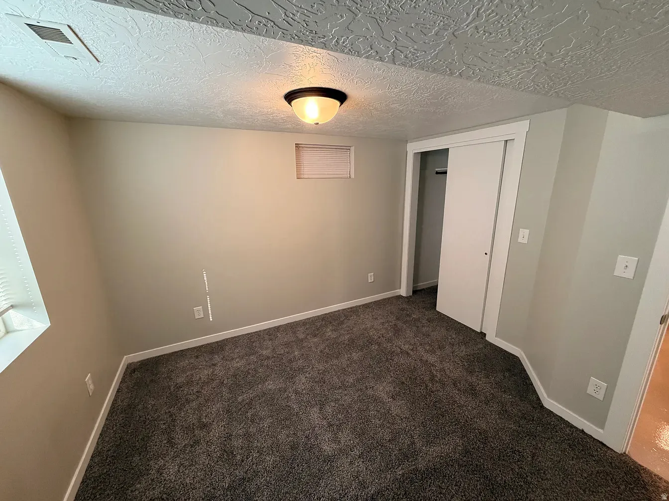 Unfurnished bedroom featuring a closet, a textured ceiling, and dark carpet