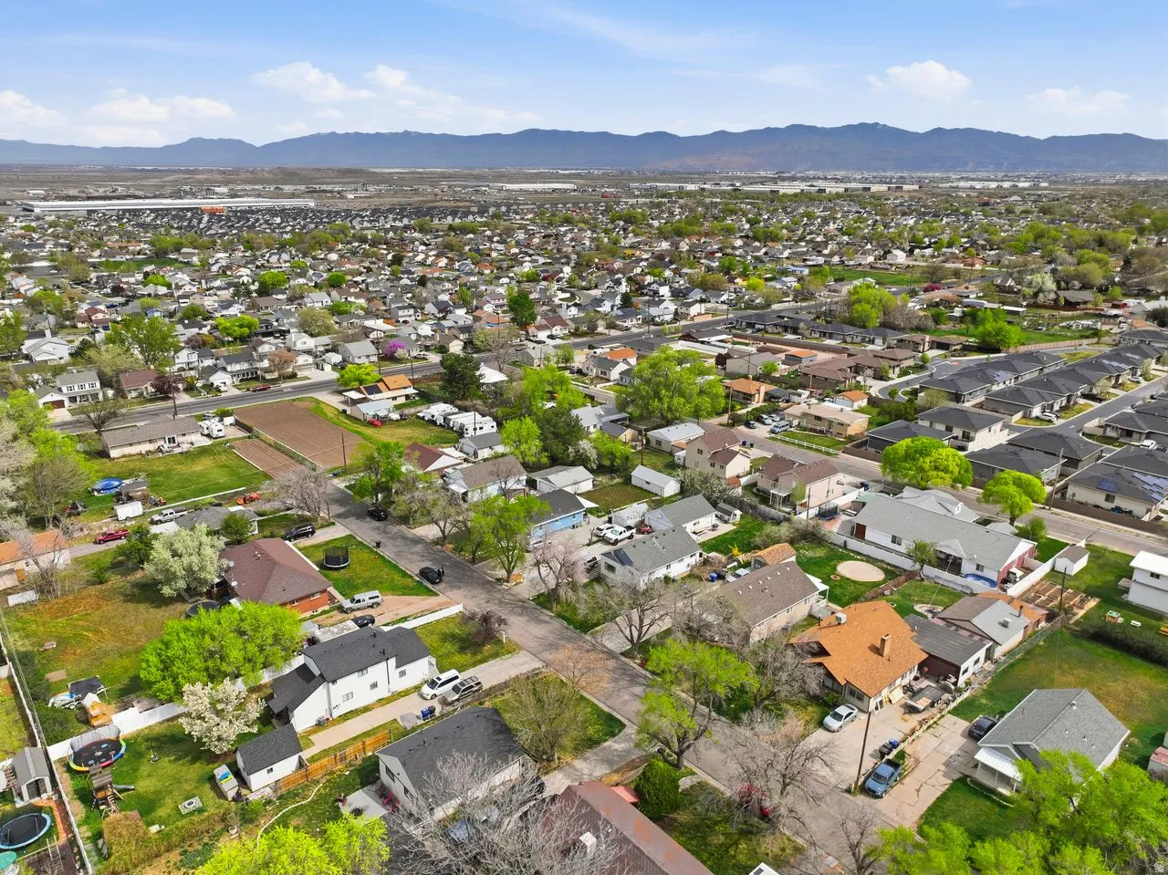 Aerial view of property and surrounding area with mountains and nearby suburban area