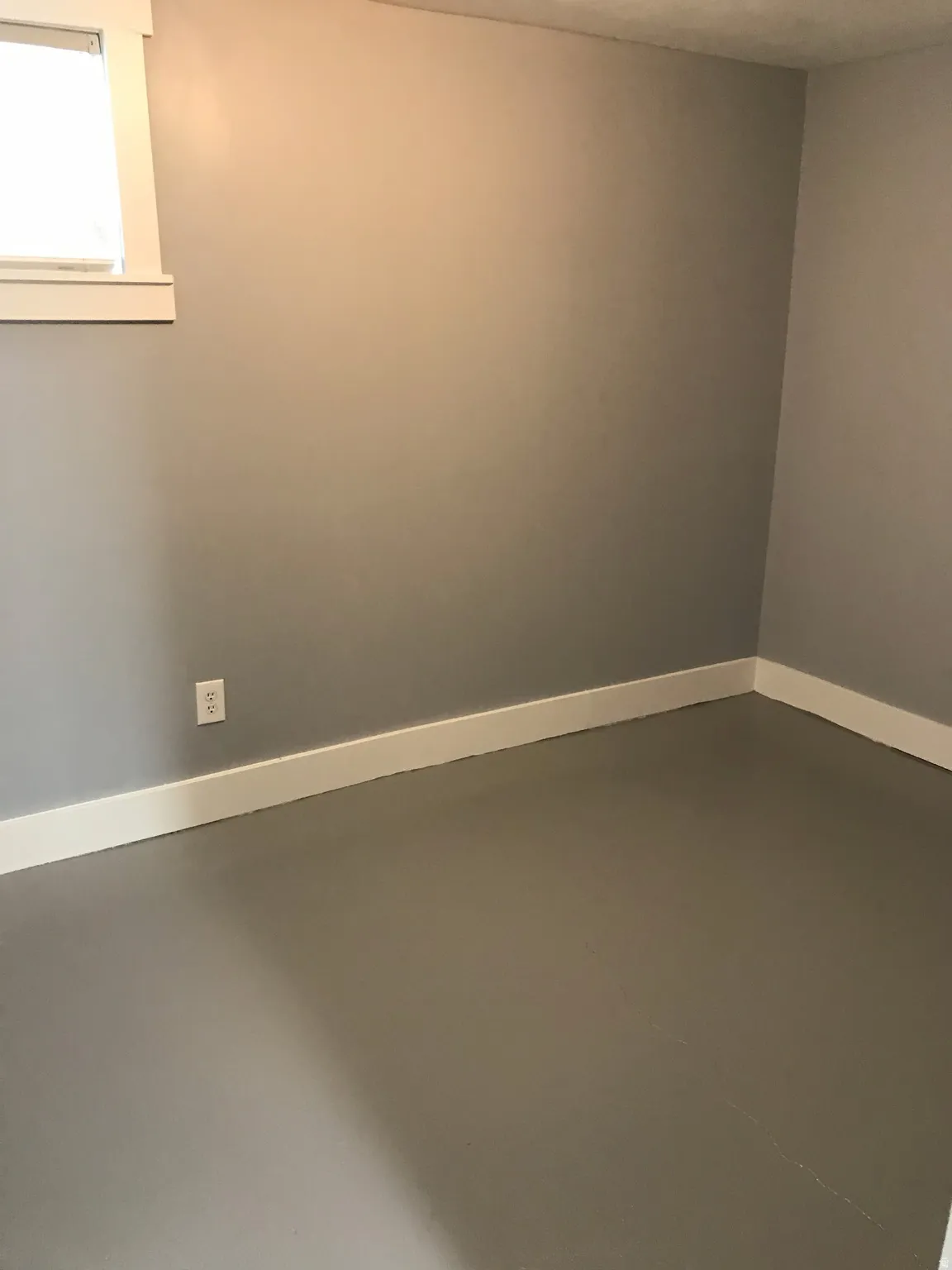 Empty room featuring baseboards and finished concrete floors
