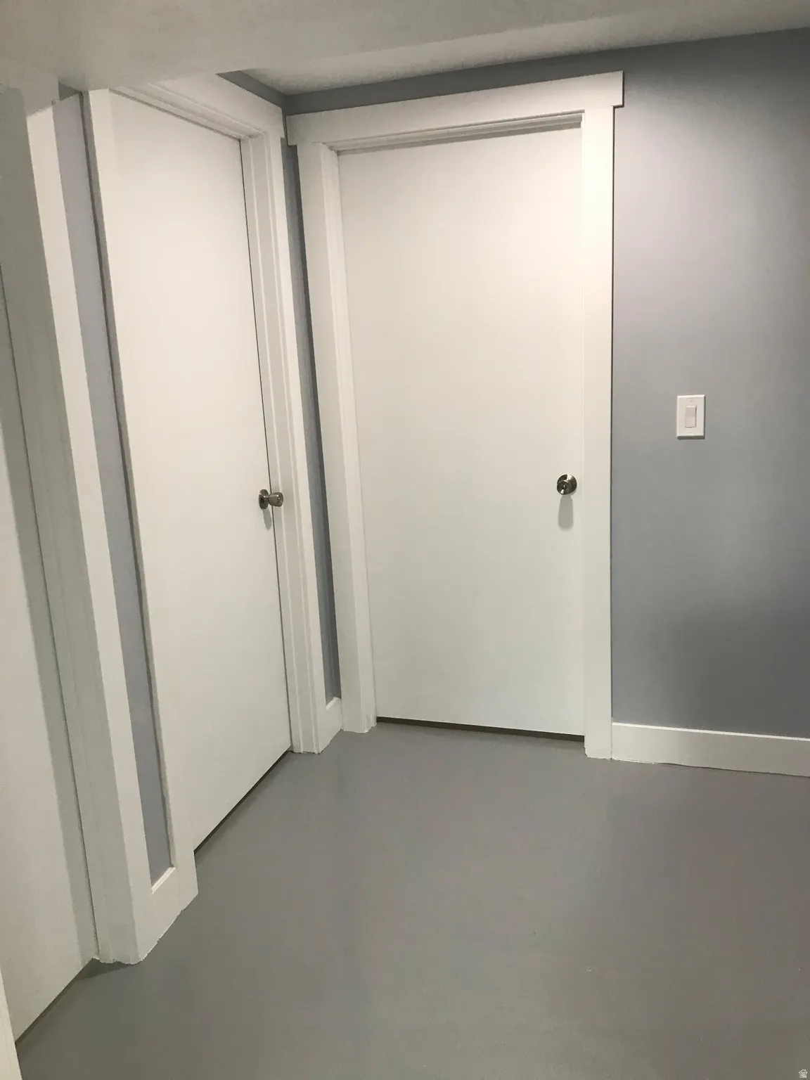 Hall with concrete flooring and baseboards
